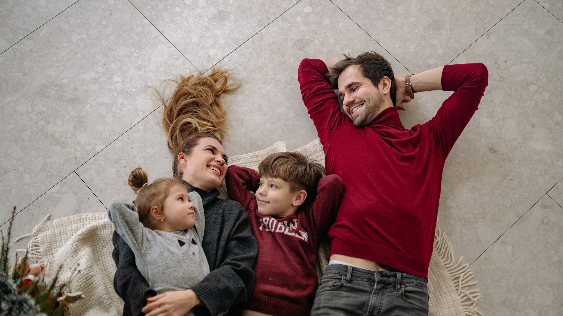 Happy family laying together on a spotless floor in their Trinity home